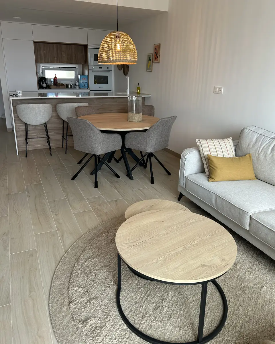 De woonkamer met bank, ronde salontafels, eettafel en de open keuken met bar